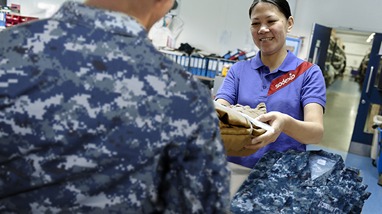 Sodexo employee distributing uniform to military personnel
