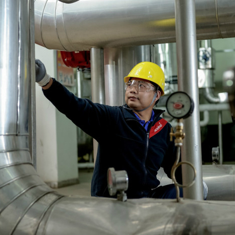 Sodexo facilities employee speaking to a colleague, holding a tablet