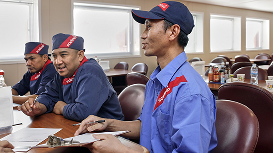 Three Sodexo employees sitting at a table and listening