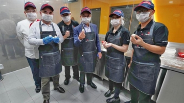 Group of people wearing aprons and Sodexo cap