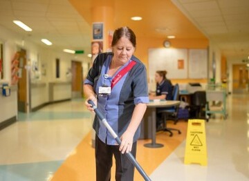 Lady cleaning hospital floor with a mop