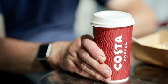 hand holding a Costa Coffee cup