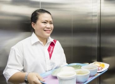 A woman holding a tray of food in an elevator