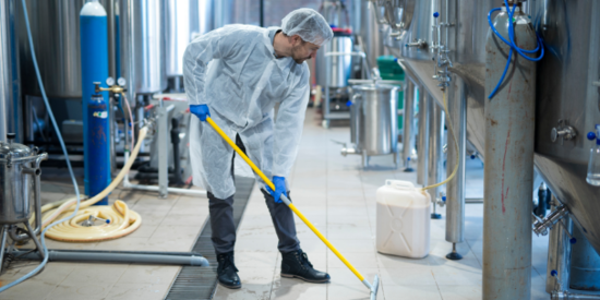 A man cleaning a factory floor with an industrial machine
