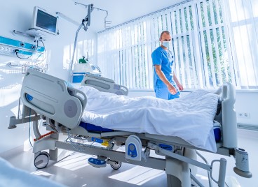 A nurse stands by a hospital bed