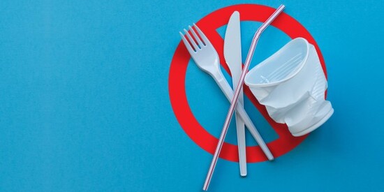 A fork and knife on a blue background, symbolizing eco-friendly choices by saying no to plastic.