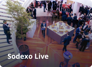 A bustling lobby filled with people. Text on image says Sodexo Live