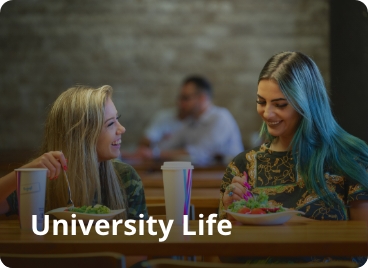 Two women enjoying a meal at a table. Text on the image says Universities