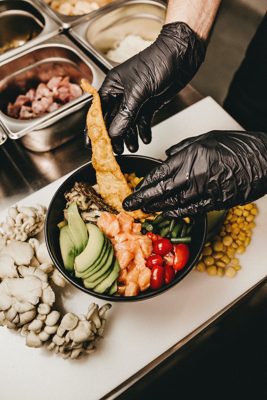 man handling ingredients with gloved hand