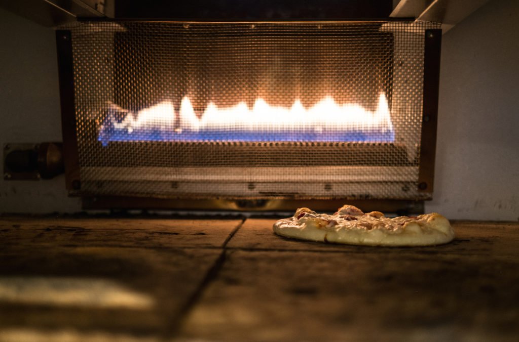Photo of pizza baking in an oven
