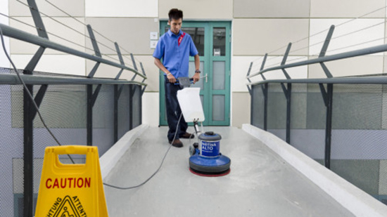 Sodexo employee cleaning a walkway with a buffing machine