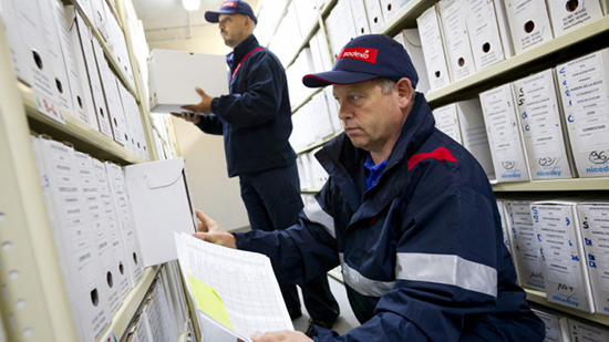 Deux employés Sodexo trient des boîtes de documents archivées