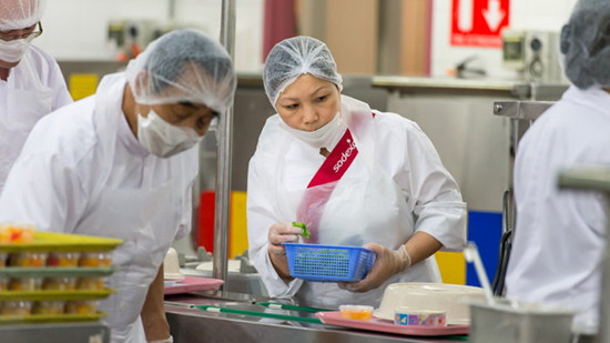 Sodexo catering employees working in a kitchen wearing hair nets and face masks