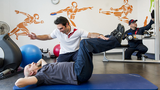 Sodexo personal trainer helping a customer to do exercises