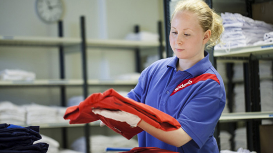 Sodexo employee folding laundry