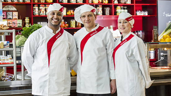 A group of Sodexo chefs posing for a picture in front of a counter