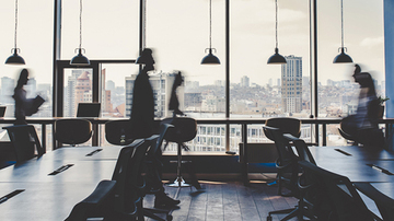 Office with blurs of people walking through it