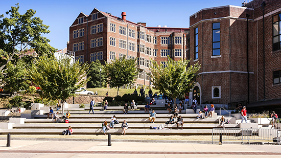 University building with students sitting on the steps in front of it