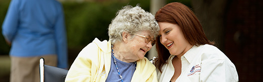 Image of elderly lady laughing with female Comfort Keeper worker